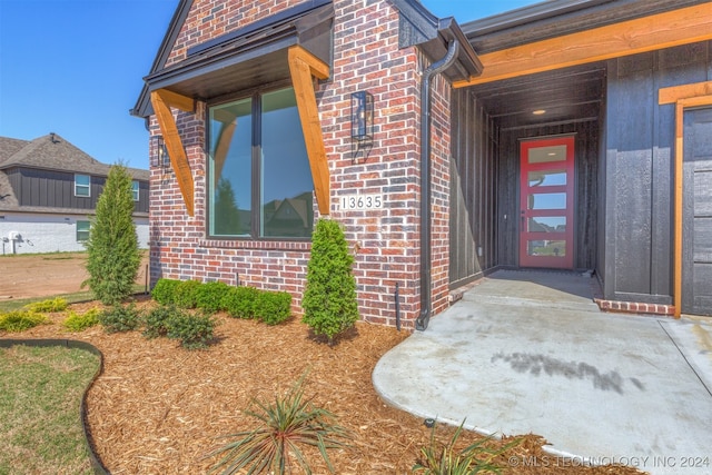 view of exterior entry with brick siding