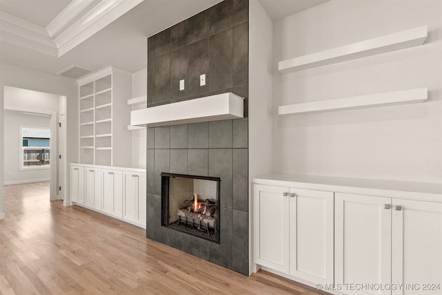 unfurnished living room featuring baseboards, visible vents, a fireplace, and light wood finished floors