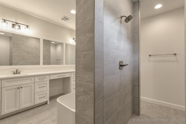 bathroom with recessed lighting, visible vents, a freestanding bath, vanity, and baseboards