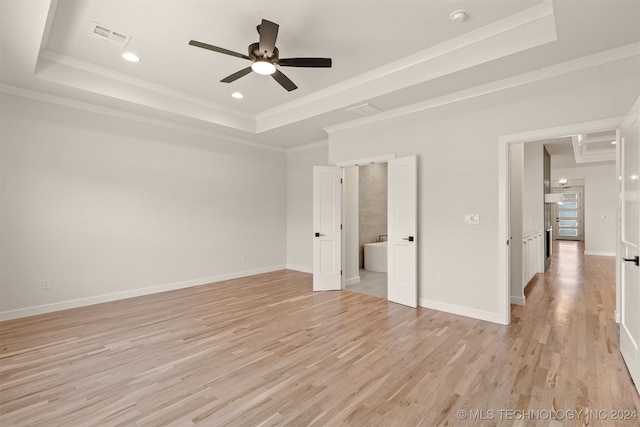 unfurnished bedroom featuring light hardwood / wood-style floors, a tray ceiling, and ceiling fan