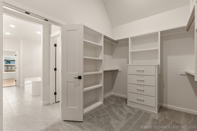 walk in closet featuring light carpet and lofted ceiling