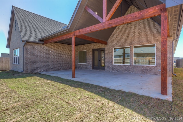 back of property with central AC, a lawn, and a patio area