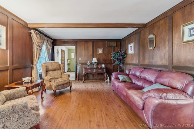 living room with beam ceiling, wooden walls, and light wood-type flooring