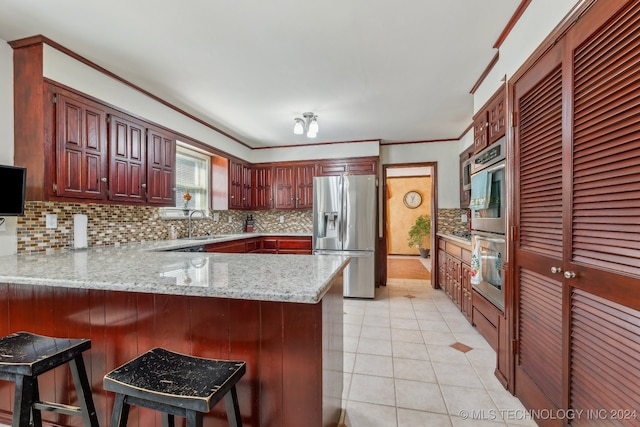 kitchen with tasteful backsplash, stainless steel fridge with ice dispenser, kitchen peninsula, and a kitchen breakfast bar