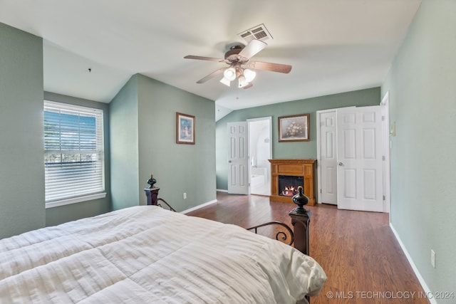 bedroom featuring ensuite bath, dark wood-type flooring, and ceiling fan