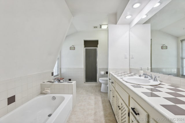 full bathroom featuring independent shower and bath, toilet, tile walls, vanity, and tile patterned flooring