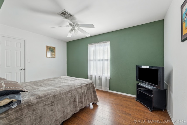 bedroom with dark hardwood / wood-style flooring and ceiling fan