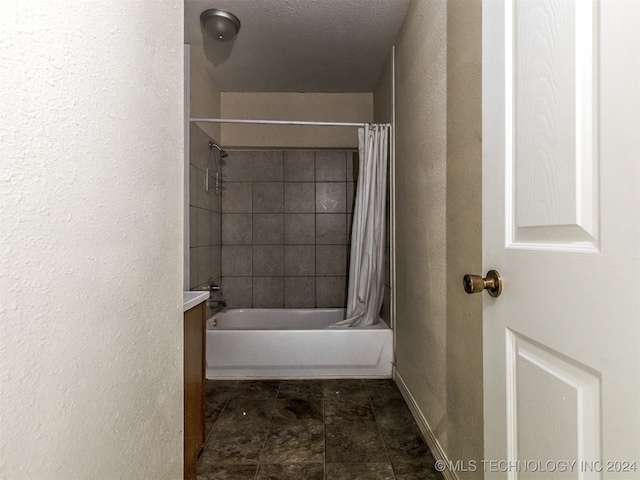 bathroom with shower / bath combo and a textured ceiling