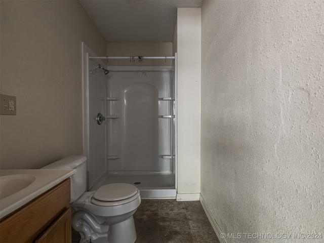 bathroom with tile patterned floors, toilet, walk in shower, and vanity