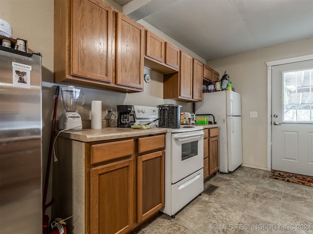 kitchen featuring white appliances and a textured ceiling