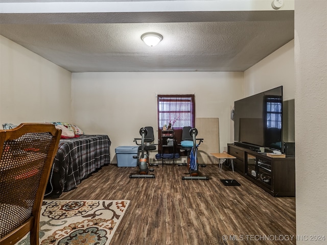 bedroom with dark hardwood / wood-style flooring and a textured ceiling