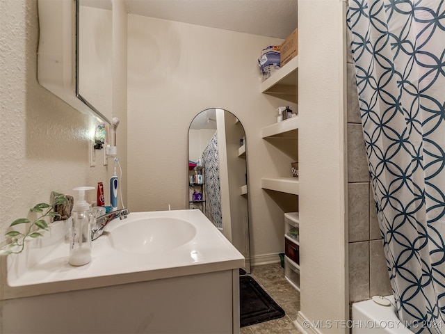 bathroom with shower / tub combo with curtain, vanity, and a textured ceiling