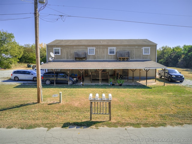 view of front of property featuring a front lawn and a carport