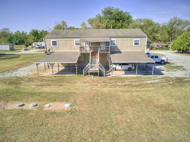 rear view of property with a carport and a yard