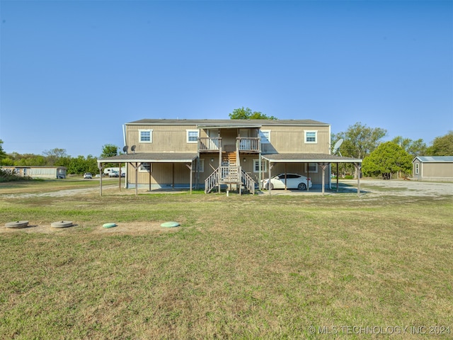 back of house with a yard, a shed, and a carport