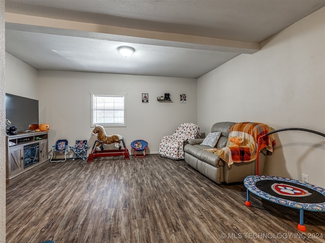 playroom featuring hardwood / wood-style flooring, beam ceiling, and a textured ceiling