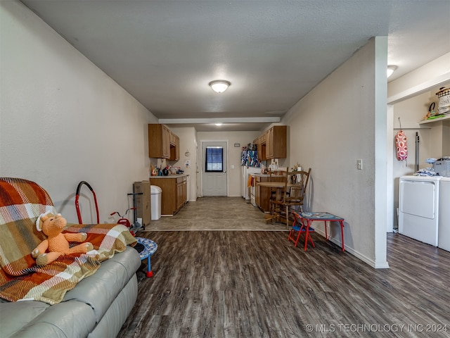 living room with washing machine and dryer and dark hardwood / wood-style flooring