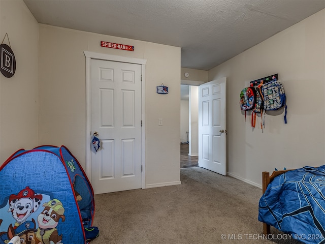 bedroom with carpet floors and a textured ceiling