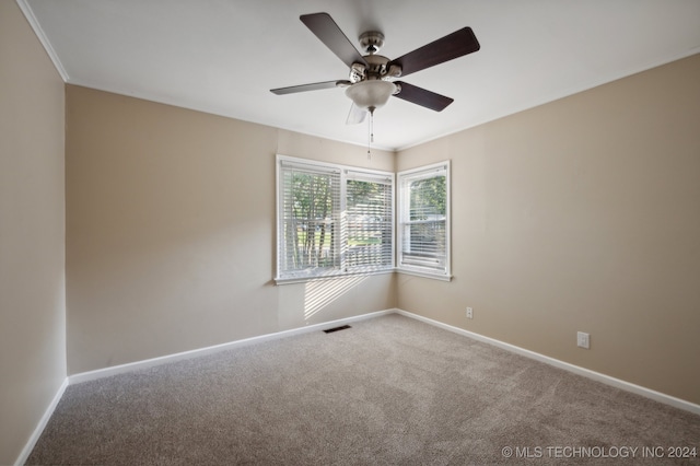 carpeted spare room featuring ceiling fan and ornamental molding