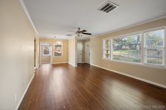 empty room with ceiling fan with notable chandelier, crown molding, and dark wood-type flooring