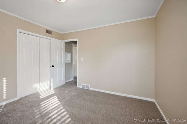 unfurnished bedroom with carpet floors, a closet, and ornamental molding