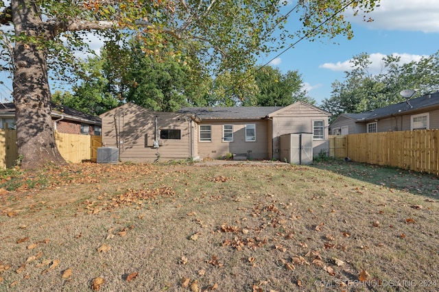 back of house with a yard and central air condition unit