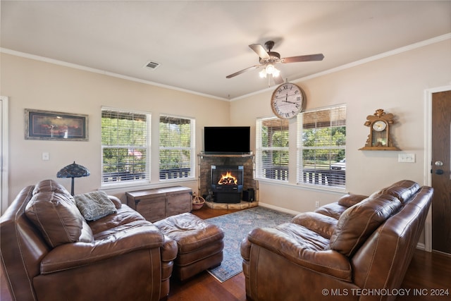 living room featuring a fireplace, ceiling fan, crown molding, and dark wood-type flooring