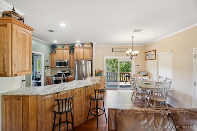 kitchen featuring stainless steel appliances, an inviting chandelier, dark hardwood / wood-style floors, and ornamental molding