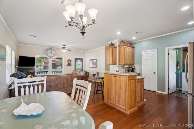 dining area with dark hardwood / wood-style flooring, ceiling fan with notable chandelier, and ornamental molding