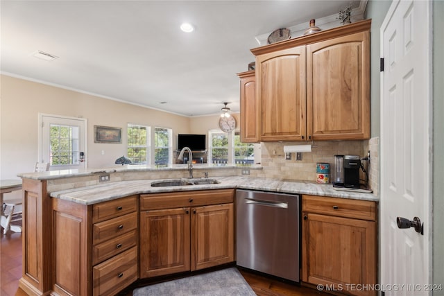 kitchen with kitchen peninsula, light stone counters, stainless steel dishwasher, and sink