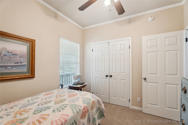 carpeted bedroom with a closet, ceiling fan, and crown molding