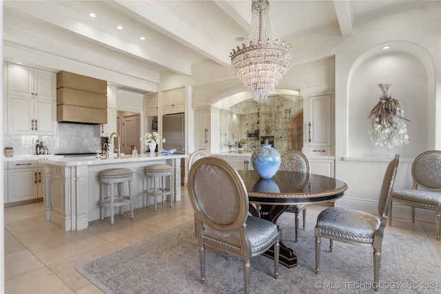 tiled dining space with beam ceiling, ornamental molding, sink, and an inviting chandelier