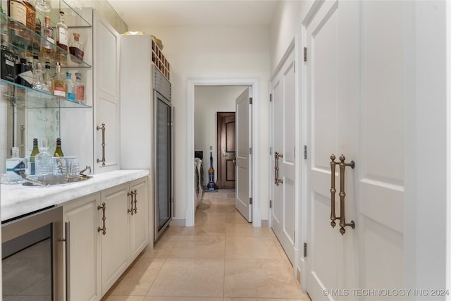 corridor featuring light tile patterned flooring and beverage cooler