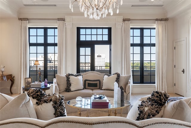 living room featuring a wealth of natural light, ornamental molding, and a chandelier