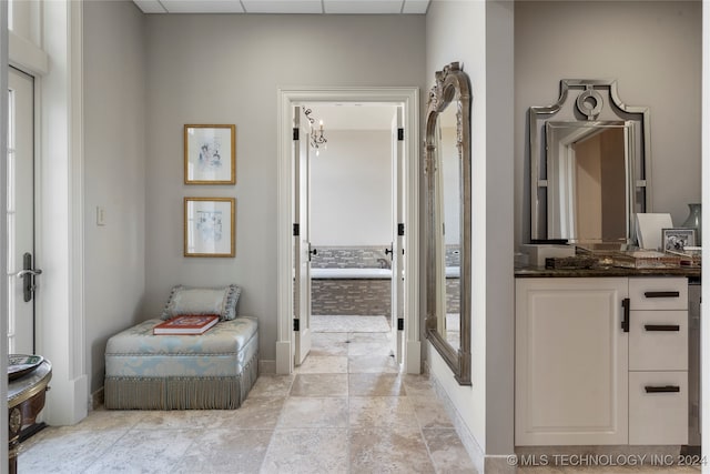 bathroom featuring vanity, a paneled ceiling, and a bathtub