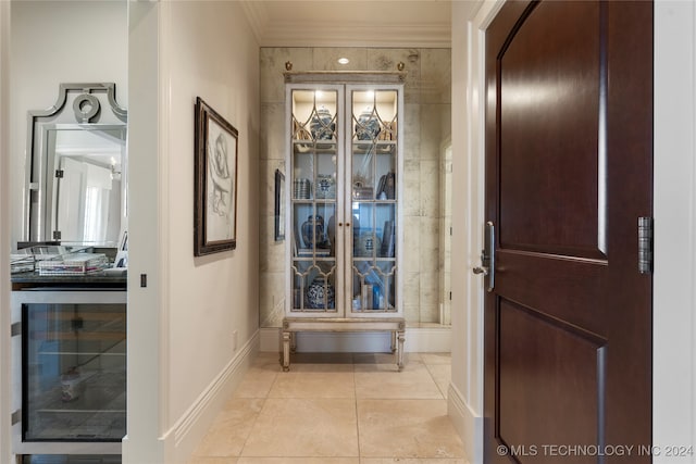 corridor with wine cooler, ornamental molding, and light tile patterned floors