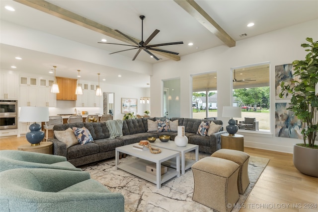 living room with beam ceiling, light wood-type flooring, and ceiling fan