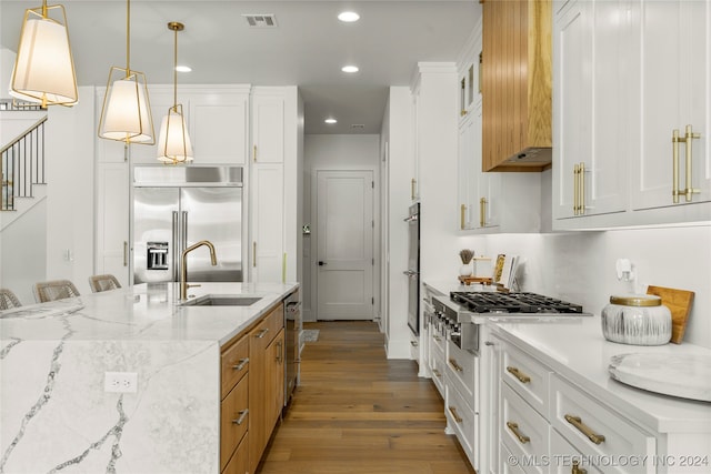 kitchen featuring white cabinetry, stainless steel appliances, and decorative light fixtures