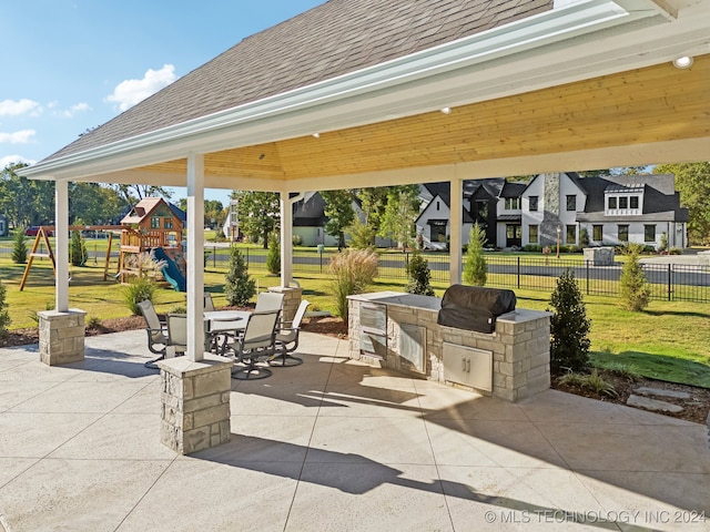 view of patio featuring area for grilling and a playground