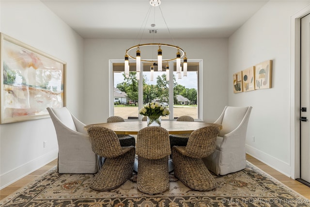 dining room featuring hardwood / wood-style floors and an inviting chandelier