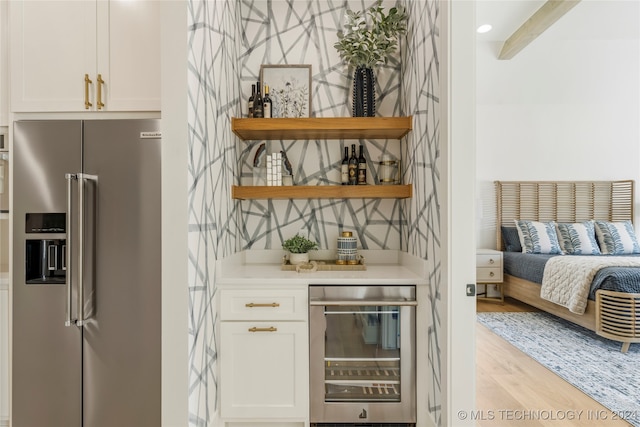 bar featuring white cabinetry, high end refrigerator, wine cooler, and light hardwood / wood-style floors