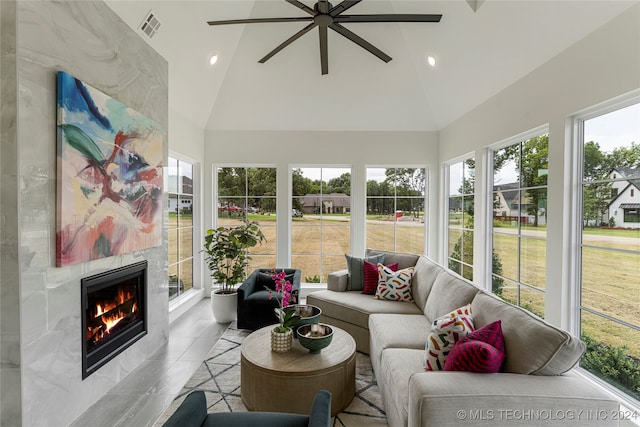 sunroom with a wealth of natural light, a premium fireplace, and vaulted ceiling