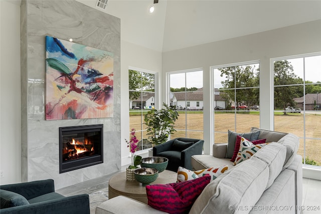 living room with a healthy amount of sunlight, a high ceiling, and a fireplace