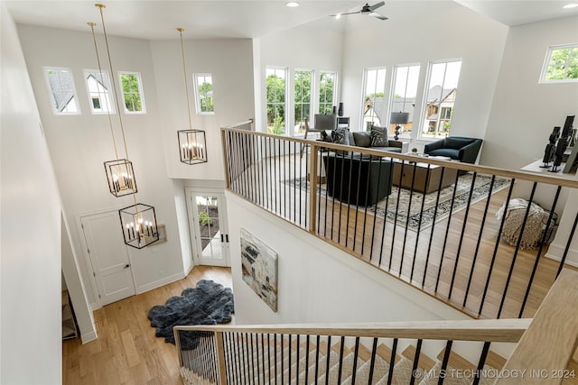 stairs with hardwood / wood-style floors and ceiling fan