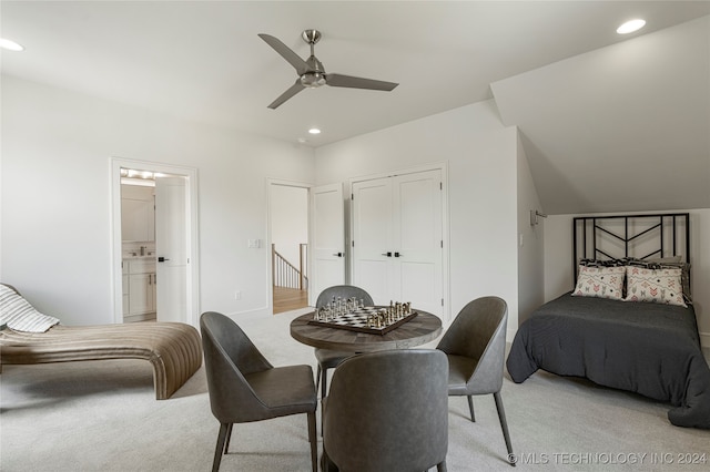 carpeted bedroom featuring lofted ceiling, a closet, connected bathroom, and ceiling fan