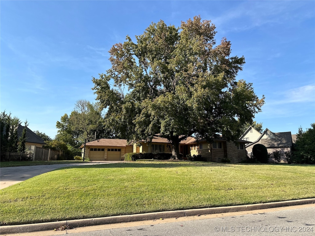 view of front of property with a garage and a front lawn