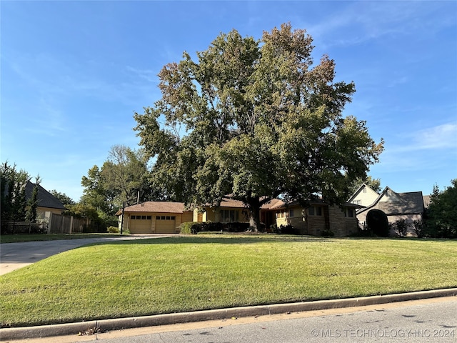 view of front of property with a garage and a front lawn