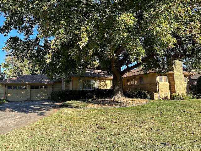 ranch-style house with a garage and a front lawn