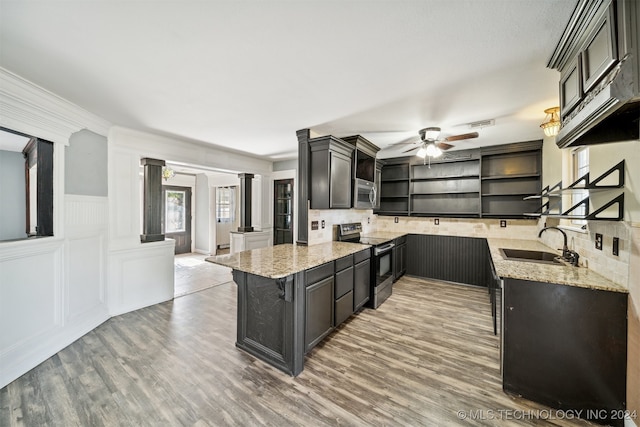 kitchen with stainless steel appliances, light hardwood / wood-style floors, tasteful backsplash, and decorative columns