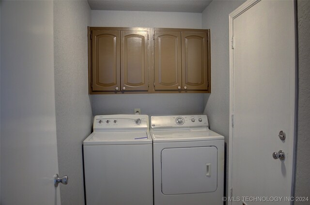 laundry area with washer and clothes dryer and cabinets